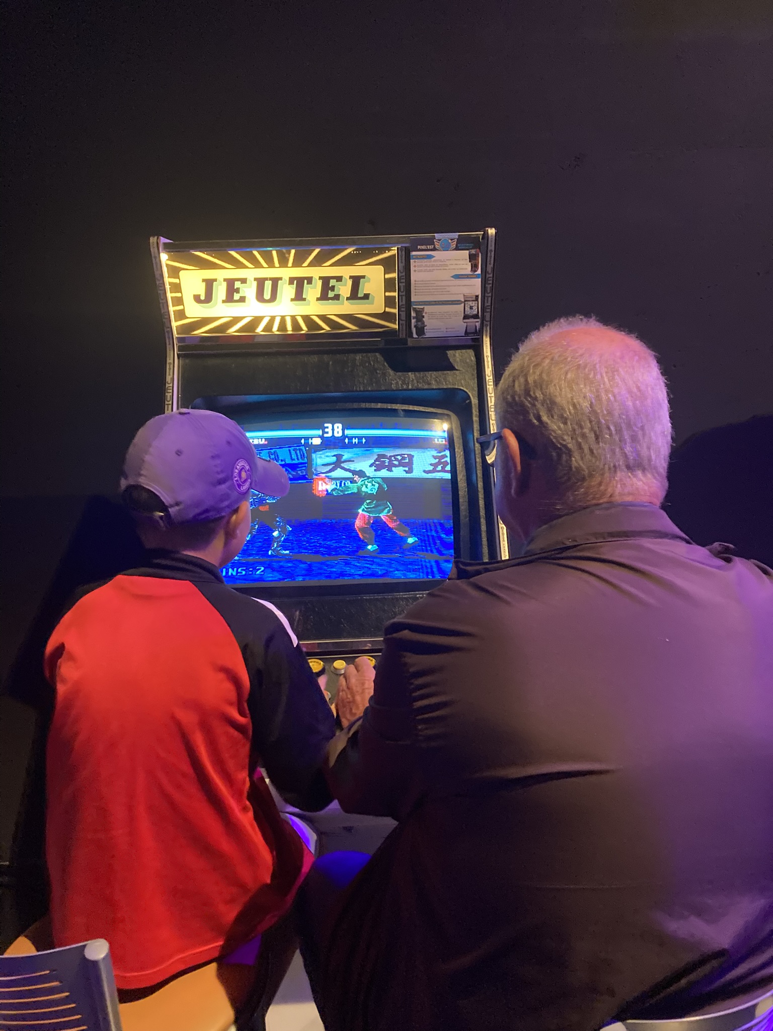 Un grand-père et son petit-fils jouant à Tekken 3
