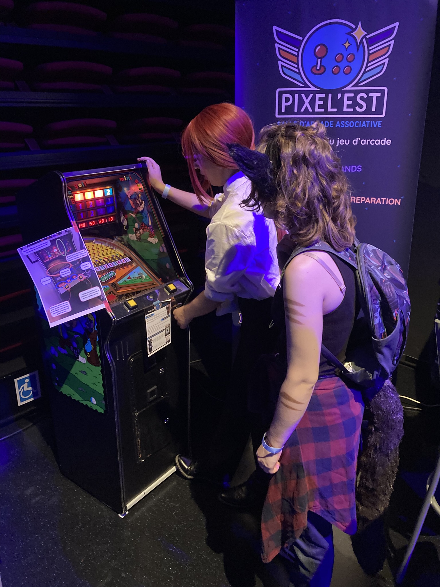Deux cosplayeuses jouant à la borne Mini-Golf